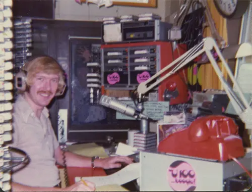 A man sitting at a table in front of a radio.