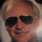 A man with sunglasses on smiling for the camera.